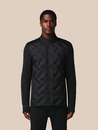 Man wearing a black quilted jacket on a beige background