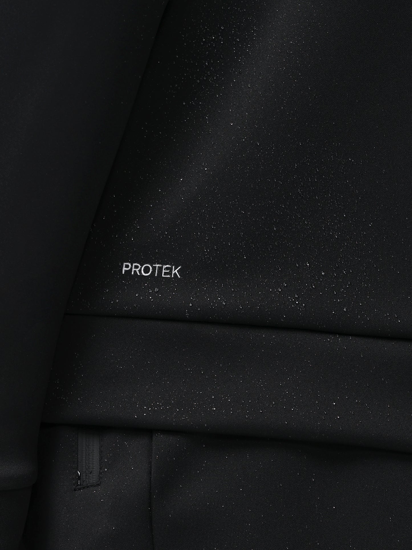 Close-up of a black textured surface with 'PROTEK' branding.