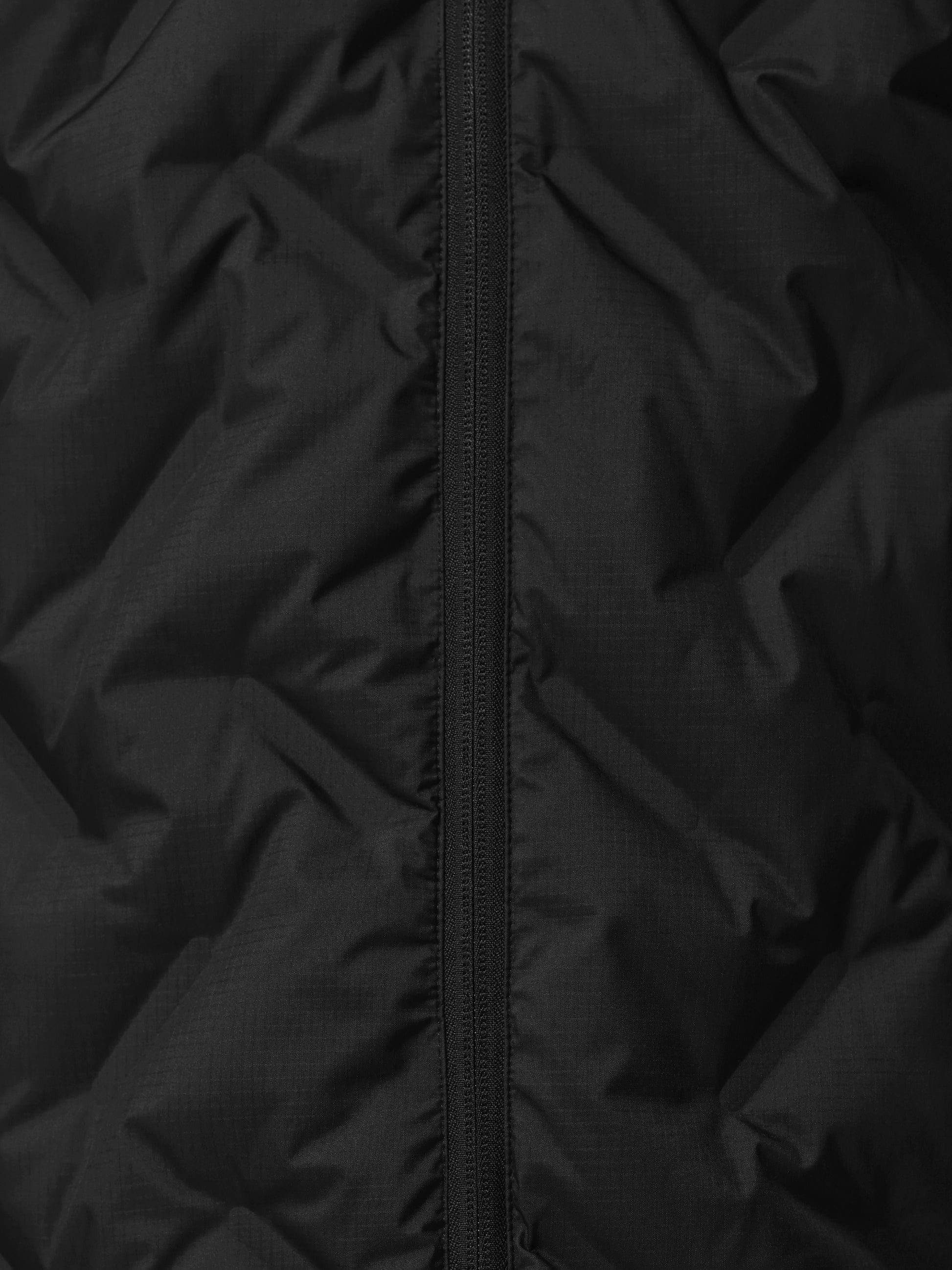Close-up of a black quilted jacket with zipper