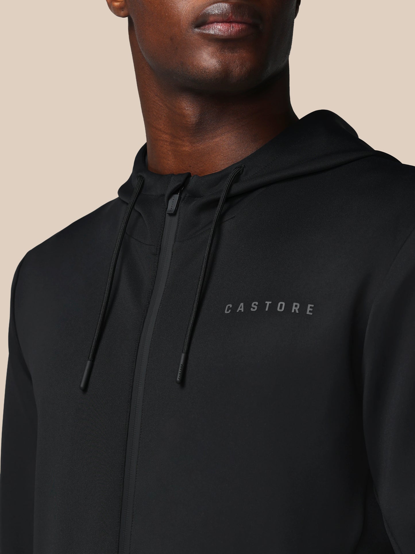 Black hoodie with 'CASTORE' logo on a beige background