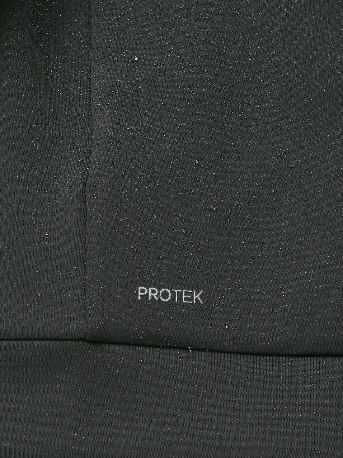 Close-up of a black fabric surface with 'PROTEK' branding.