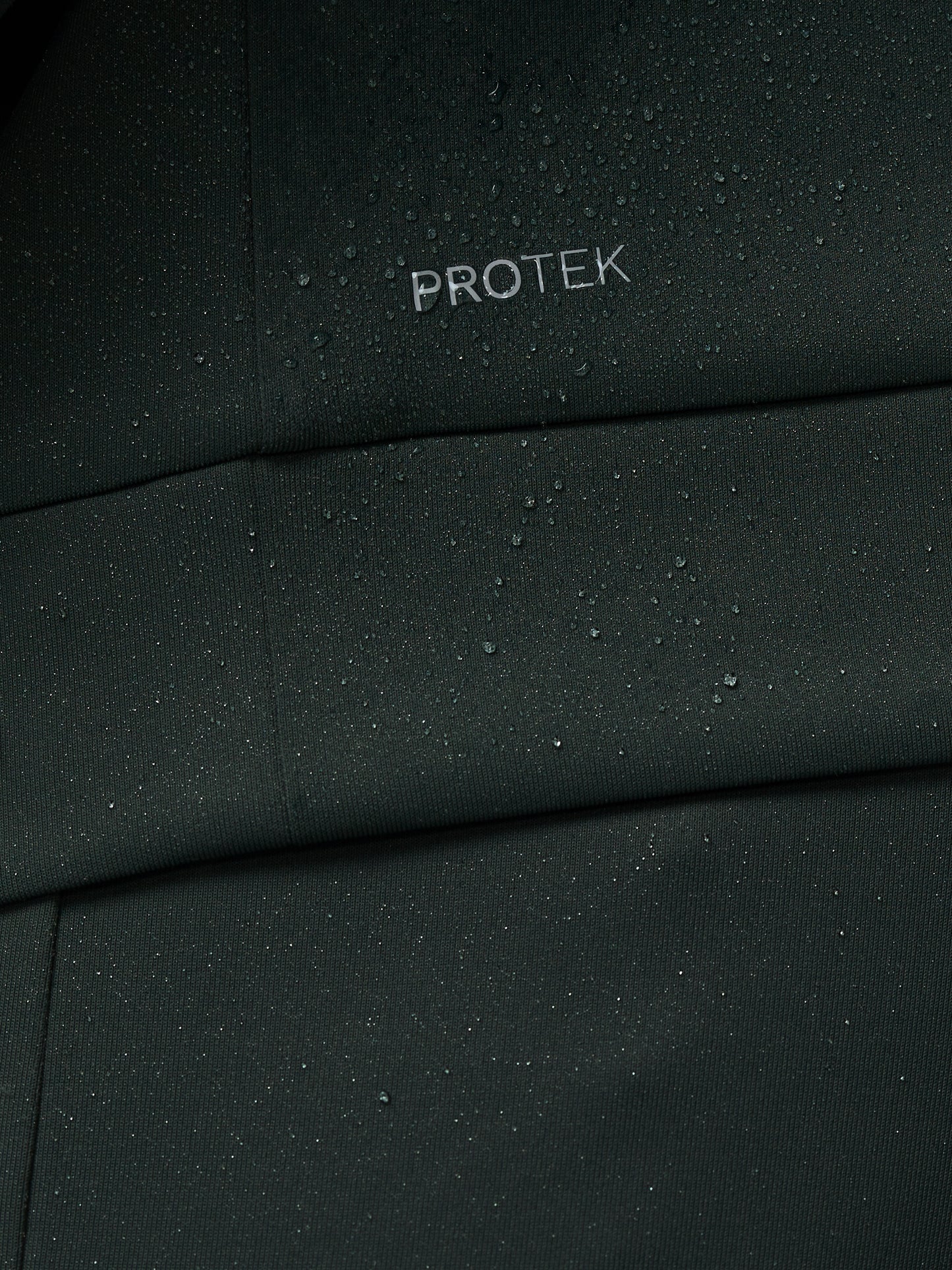 Close-up of a black fabric with 'PROTEK' branding.