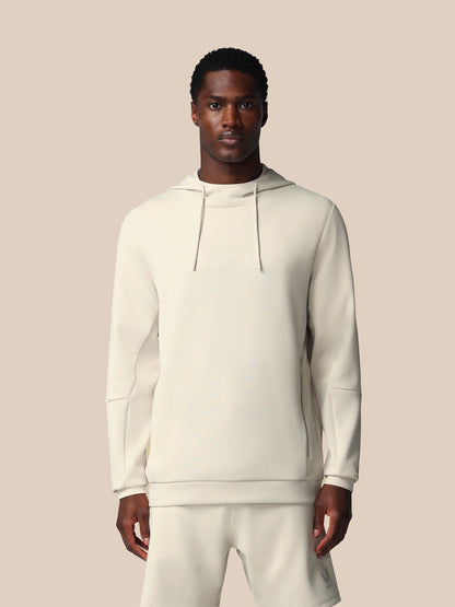 Man wearing a white hoodie and pants on a beige background