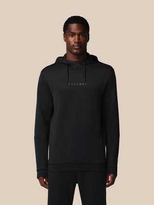 Man wearing a black hoodie with 'CASTORE' branding on a beige background