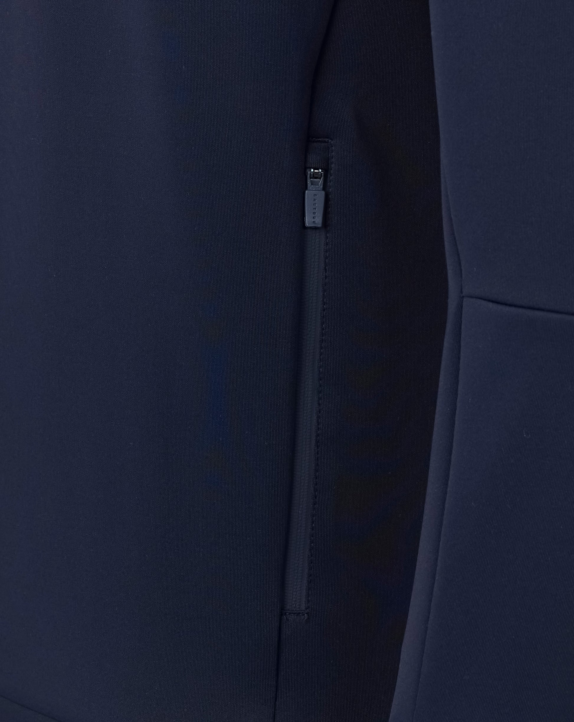 Navy blue coat with a zipper detail on a dark background