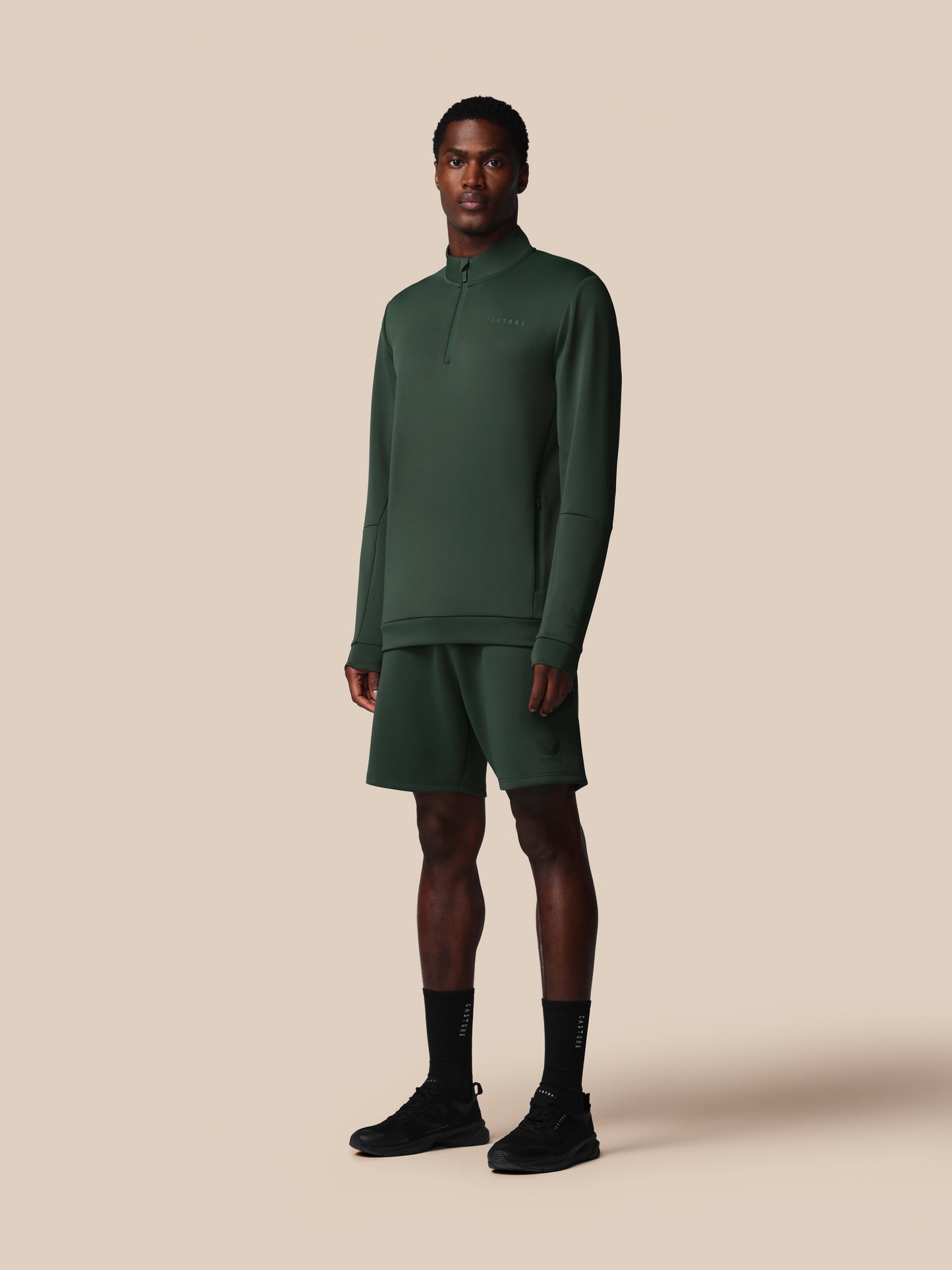 Man wearing a green tracksuit on a beige background