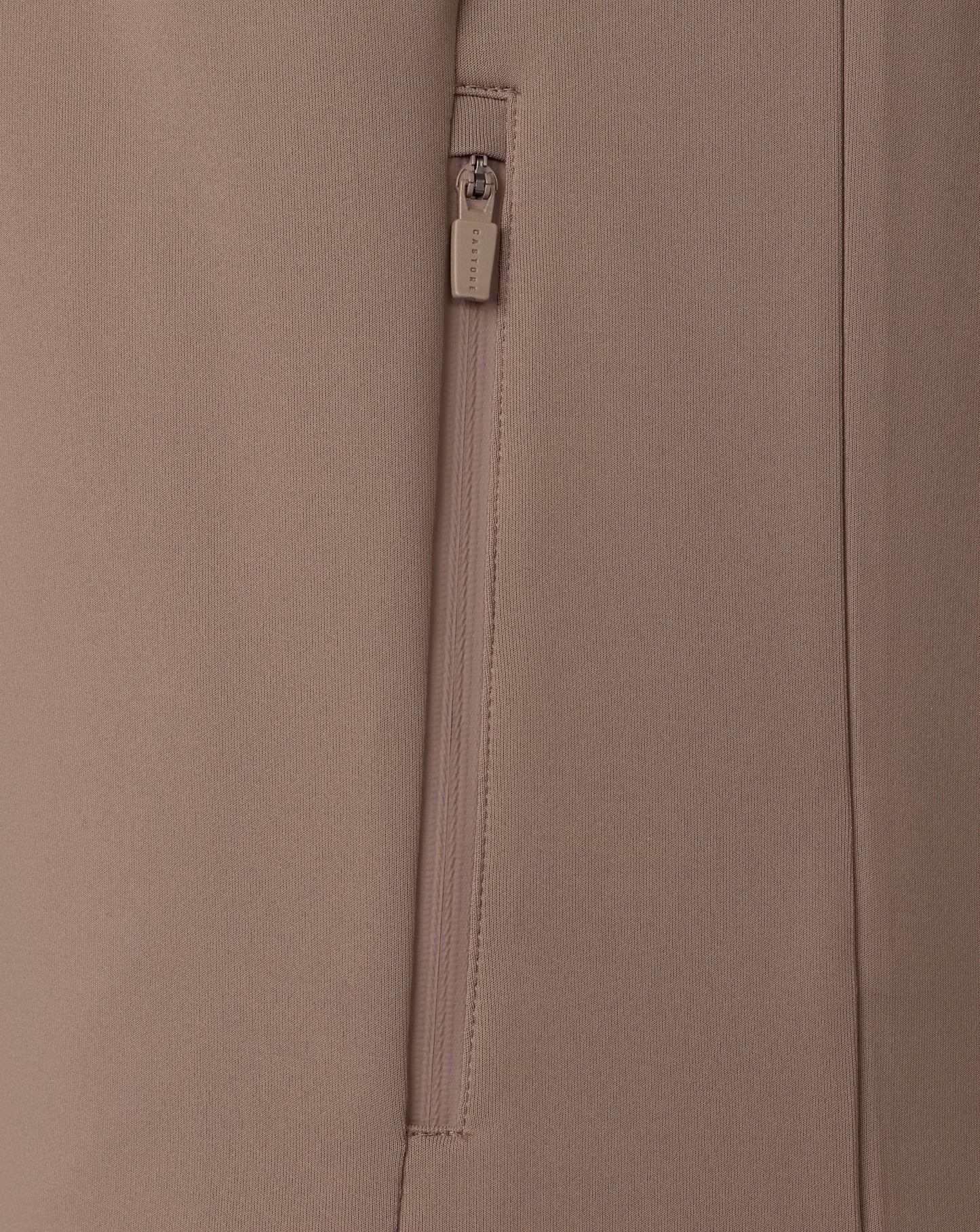 Close-up of a beige fabric with a zipper and brand label.