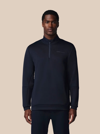 Man wearing a black quarter-zip sweatshirt on a beige background