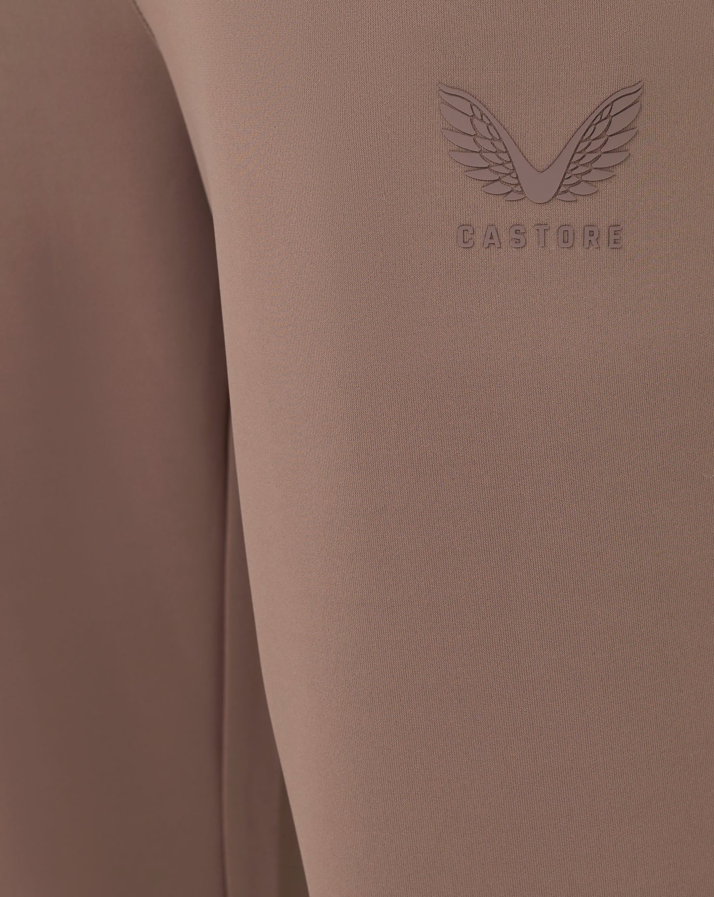 Brown fabric with 'Castore' logo on a matching brown background
