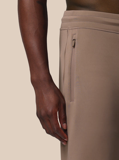 Beige pants with a zipper pocket on a neutral background