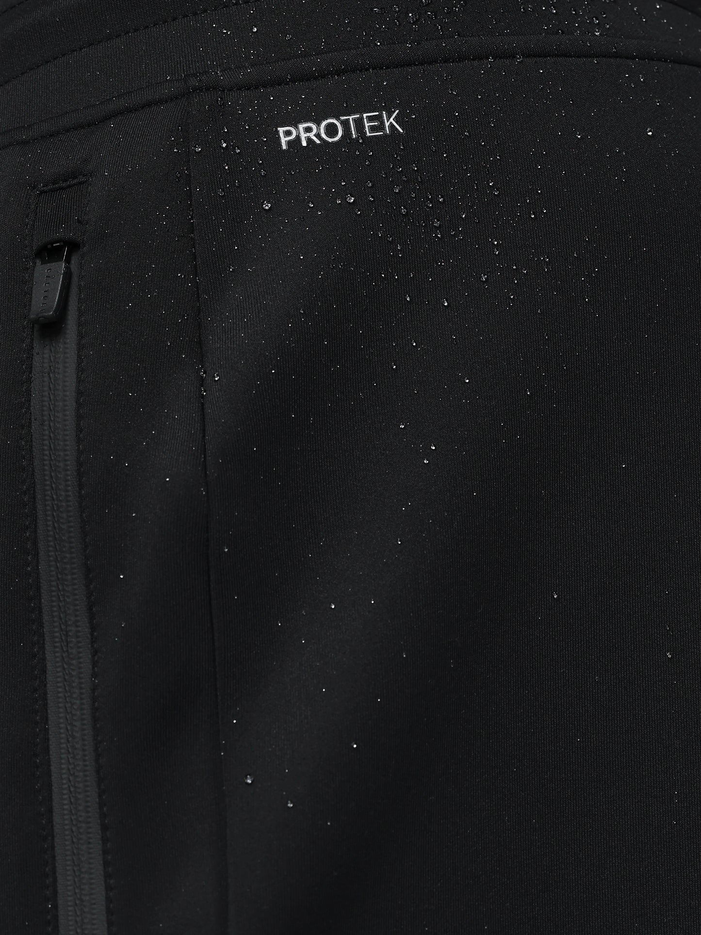 Black jacket with 'PROTEK' branding on a dark background
