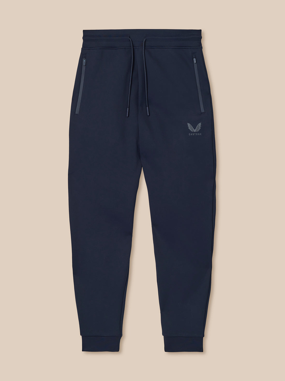 Navy blue jogger pants with a brand logo on a beige background