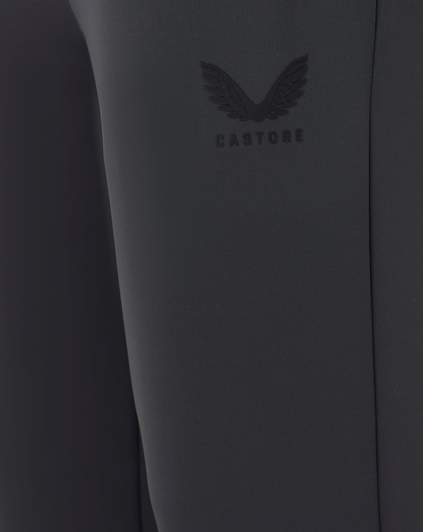 Close-up of a dark gray garment with a brand logo on a plain background