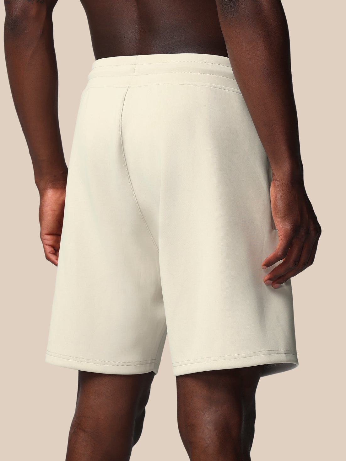 White shorts worn by a person on a beige background
