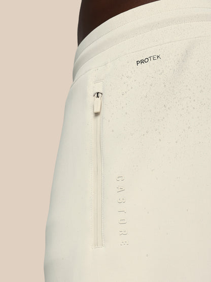 Light gray pants with a zipper and 'Protek' branding on a beige background