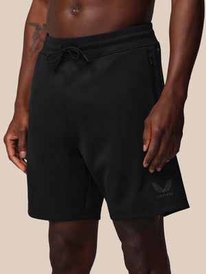 Black shorts worn by a person on a beige background