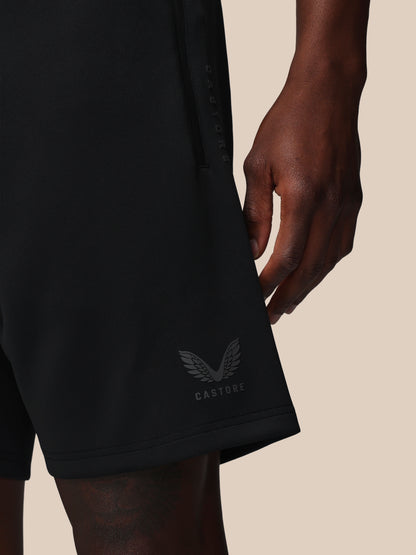 Black shorts with a brand logo on a beige background