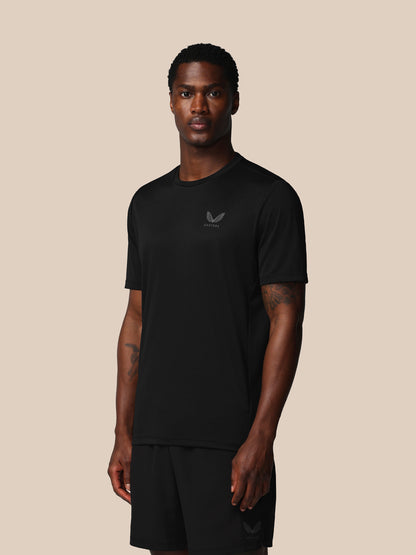 Man wearing a black t-shirt with a logo on a beige background
