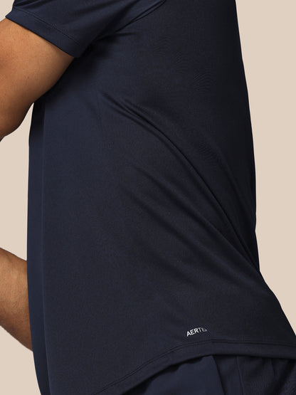 Navy blue athletic shirt with brand logo on a beige background