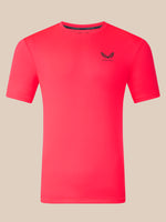 A bright pink short-sleeve athletic t-shirt with a small black winged logo and the brand name 'CASTORE' printed on the left chest, displayed on a solid beige background.