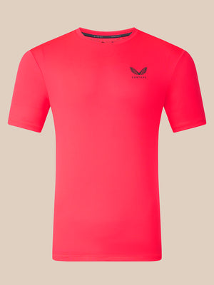 A bright pink short-sleeve athletic t-shirt with a small black winged logo and the brand name 'CASTORE' printed on the left chest, displayed on a solid beige background.