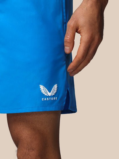 Blue shorts with a white logo and text on a beige background