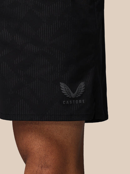Black athletic shorts with a visible brand logo on a beige background