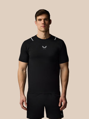 Man wearing a black athletic outfit with a logo on a beige background
