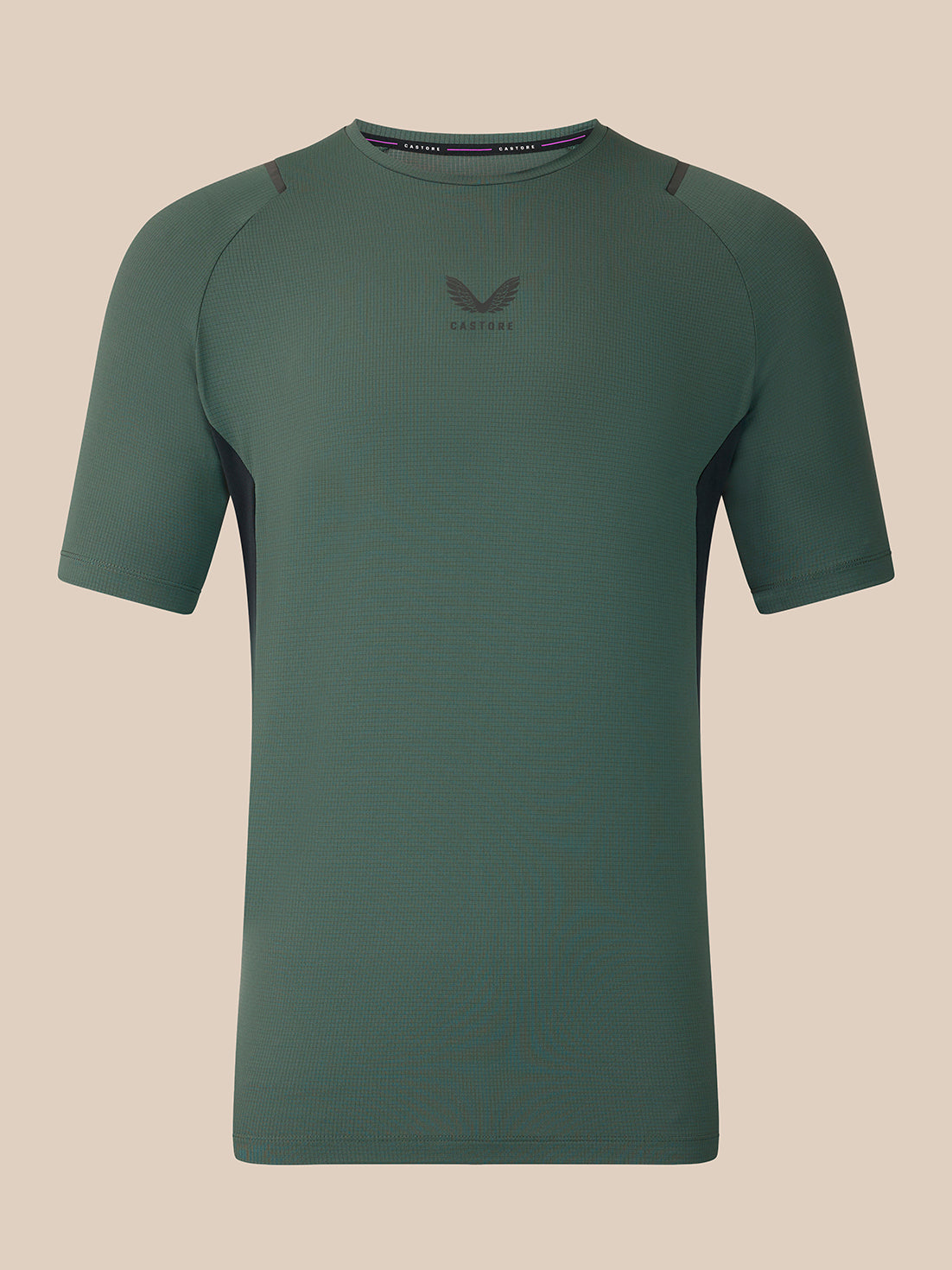 A dark green short-sleeve athletic t-shirt with a subtle winged logo and 'CASTORE' text on the center chest, displayed against a solid beige background.