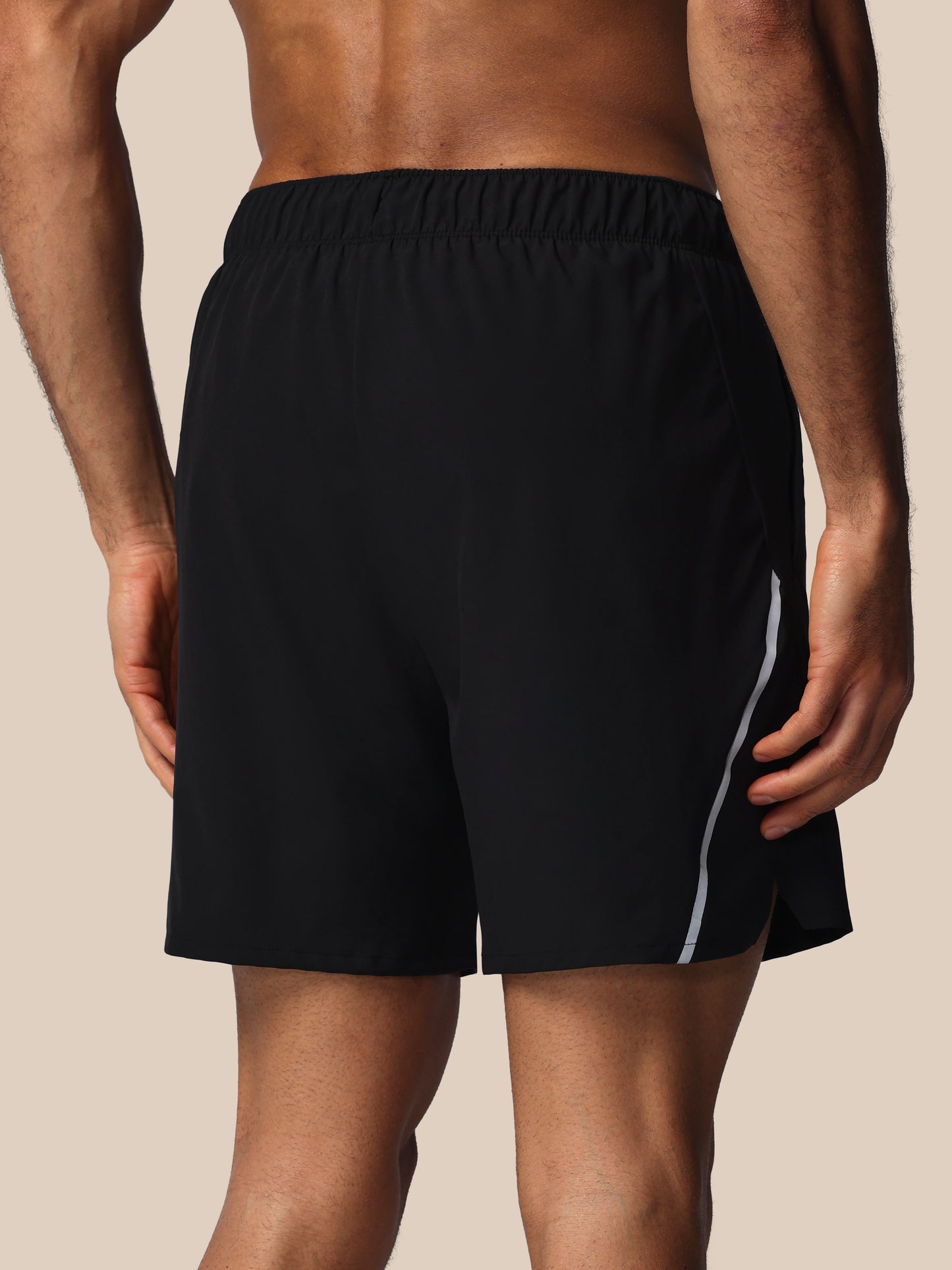 Black shorts with a white stripe on a beige background