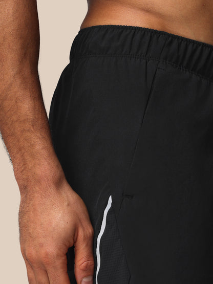 Black athletic shorts with a white stripe on a beige background