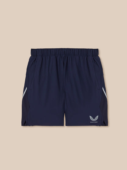 Navy athletic shorts with a logo on a beige background