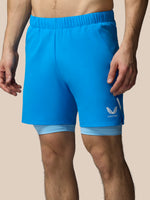 Blue athletic shorts with a logo on a beige background
