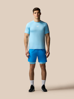 Man wearing a light blue athletic shirt and shorts on a beige background
