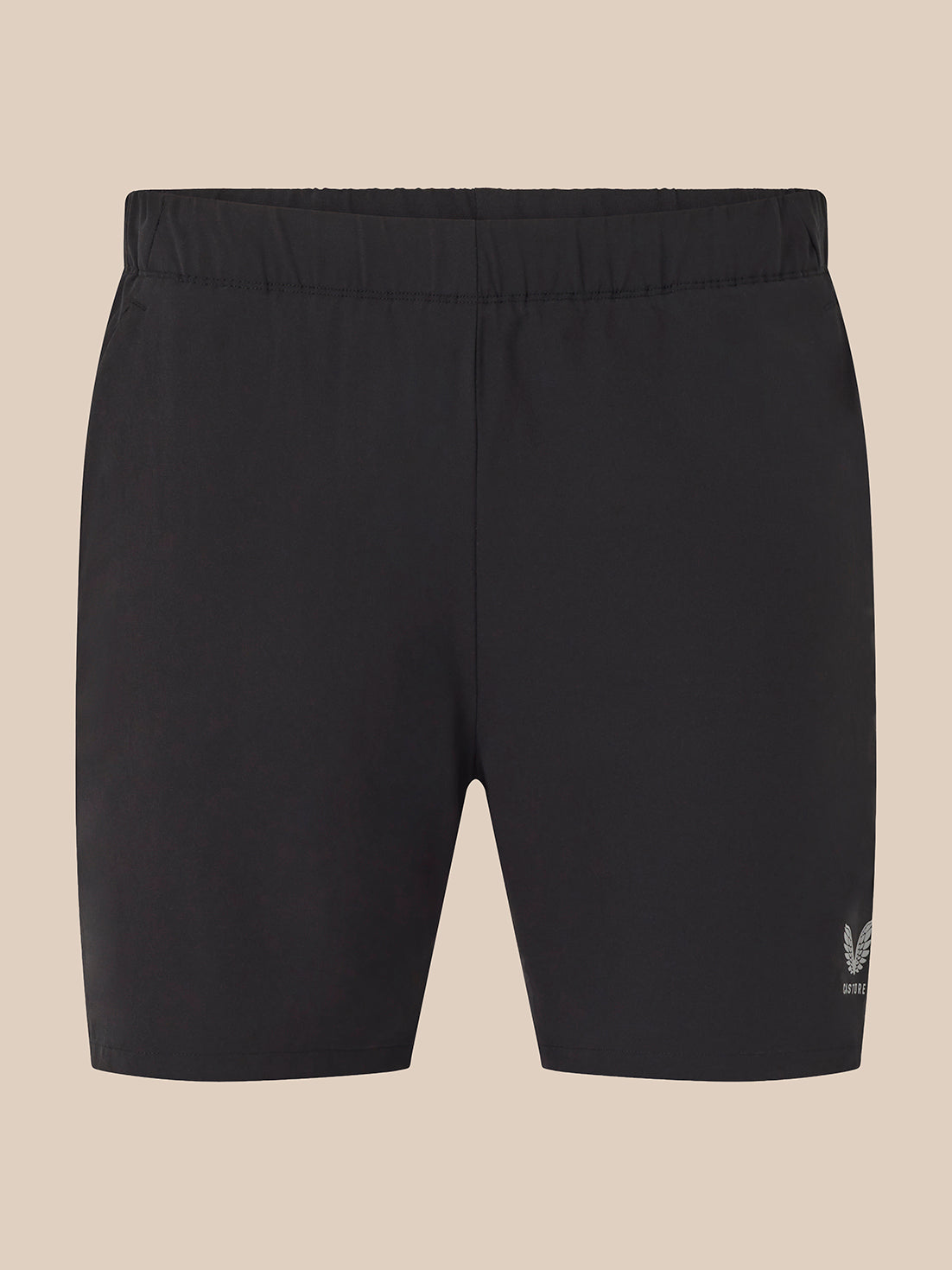 Black athletic shorts with an elastic waistband and a small white embroidered logo on the lower left leg, shown against a solid beige background.
