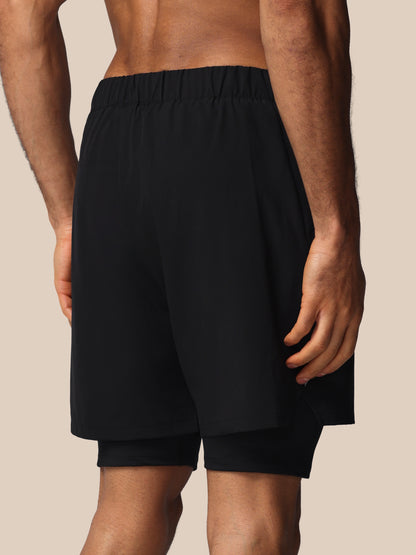 Black shorts worn by a person on a beige background