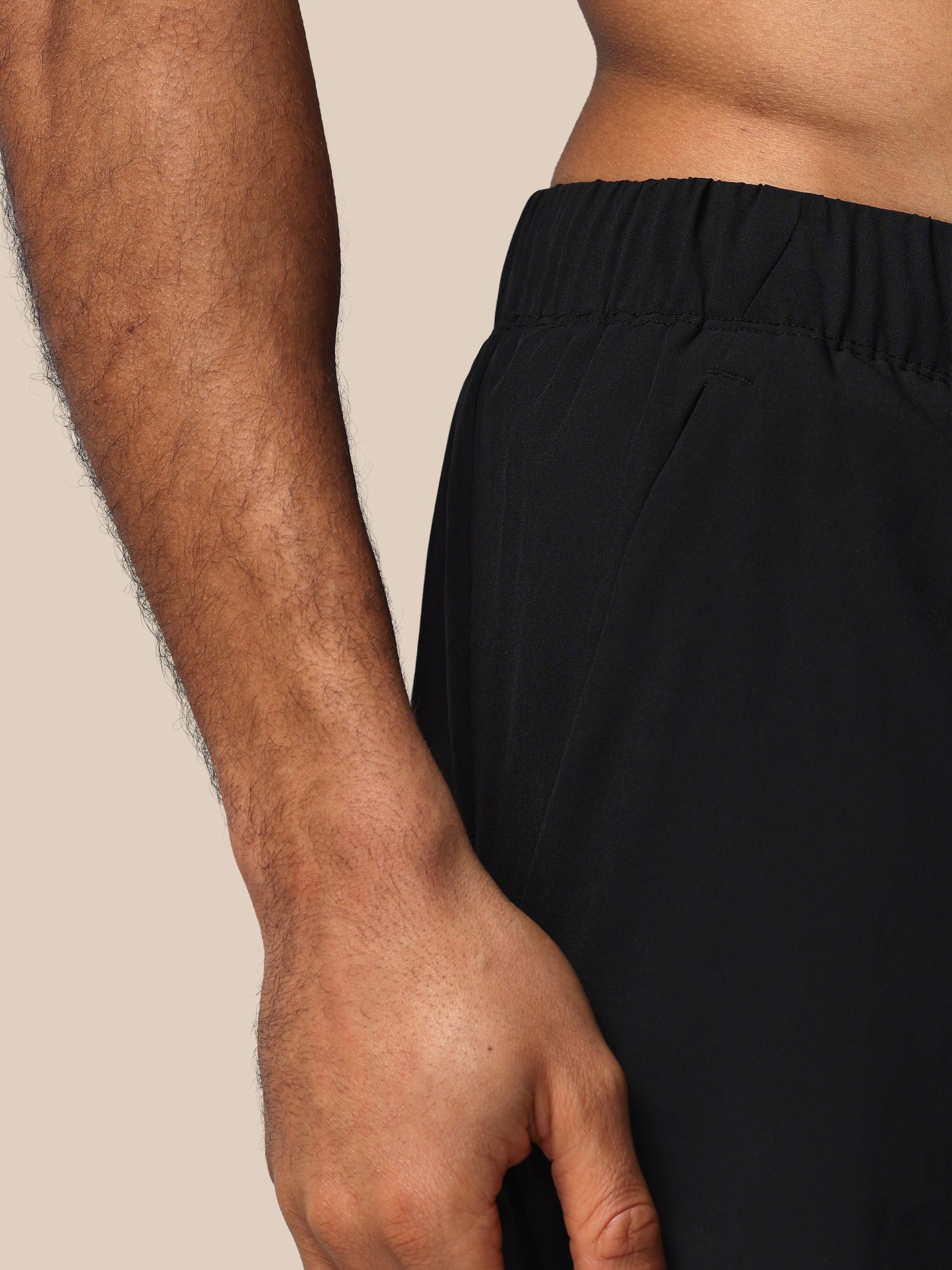 Person wearing black pants with a neutral background