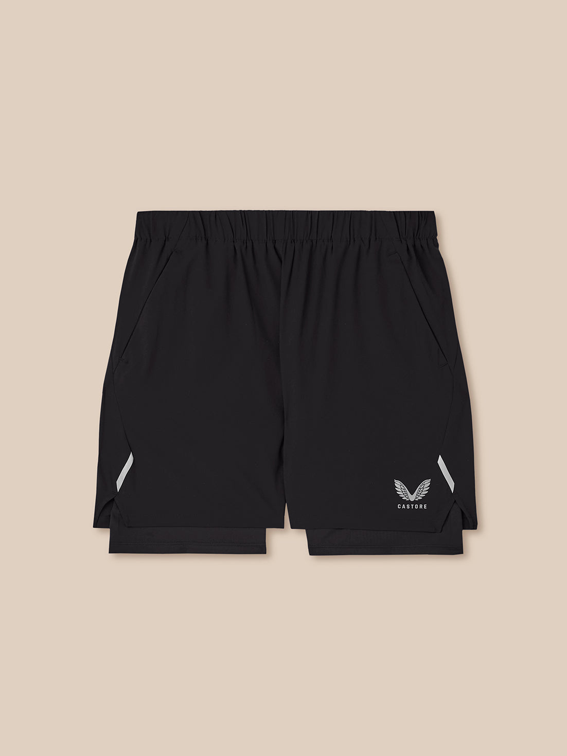 Black athletic shorts with a logo on a beige background
