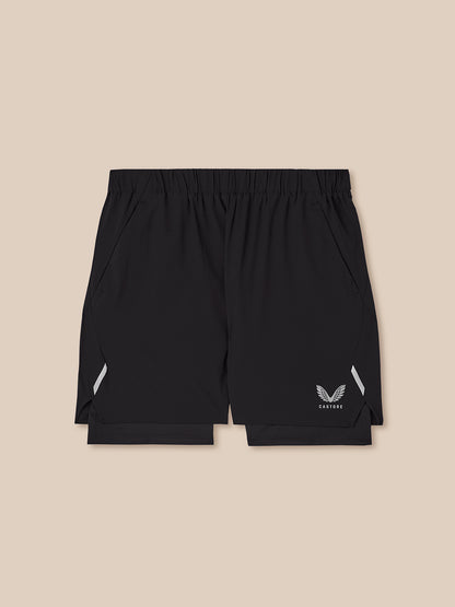 Black athletic shorts with a logo on a beige background
