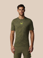 Man wearing a green athletic outfit with a logo on a beige background