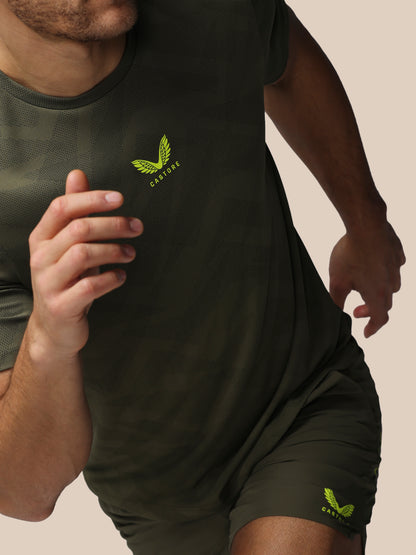 Person wearing a dark green t-shirt and shorts with a logo on a beige background