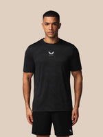 Man wearing a black t-shirt with a logo on a beige background
