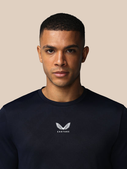 Man wearing a black sweatshirt with a logo on a beige background