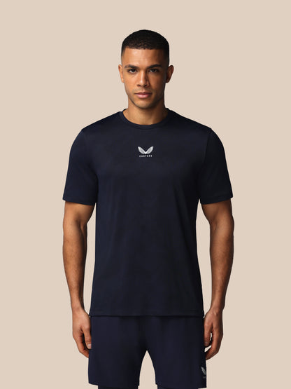 Man wearing a black t-shirt with a logo on a beige background