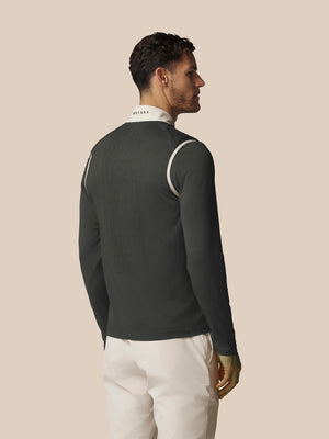 Man wearing a dark long-sleeve shirt with white accents on a beige background