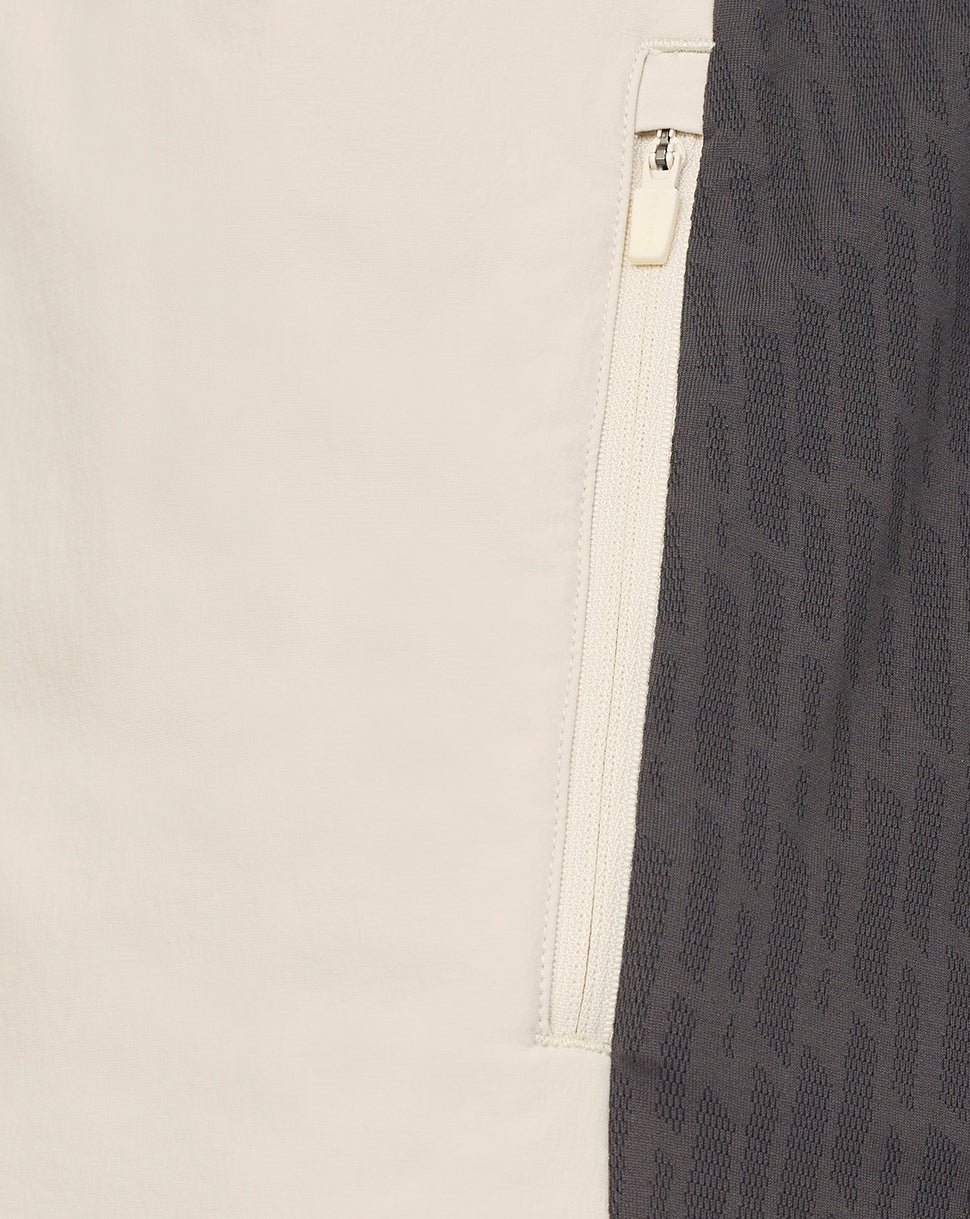 Close-up of a beige and black patterned fabric with a zipper detail.