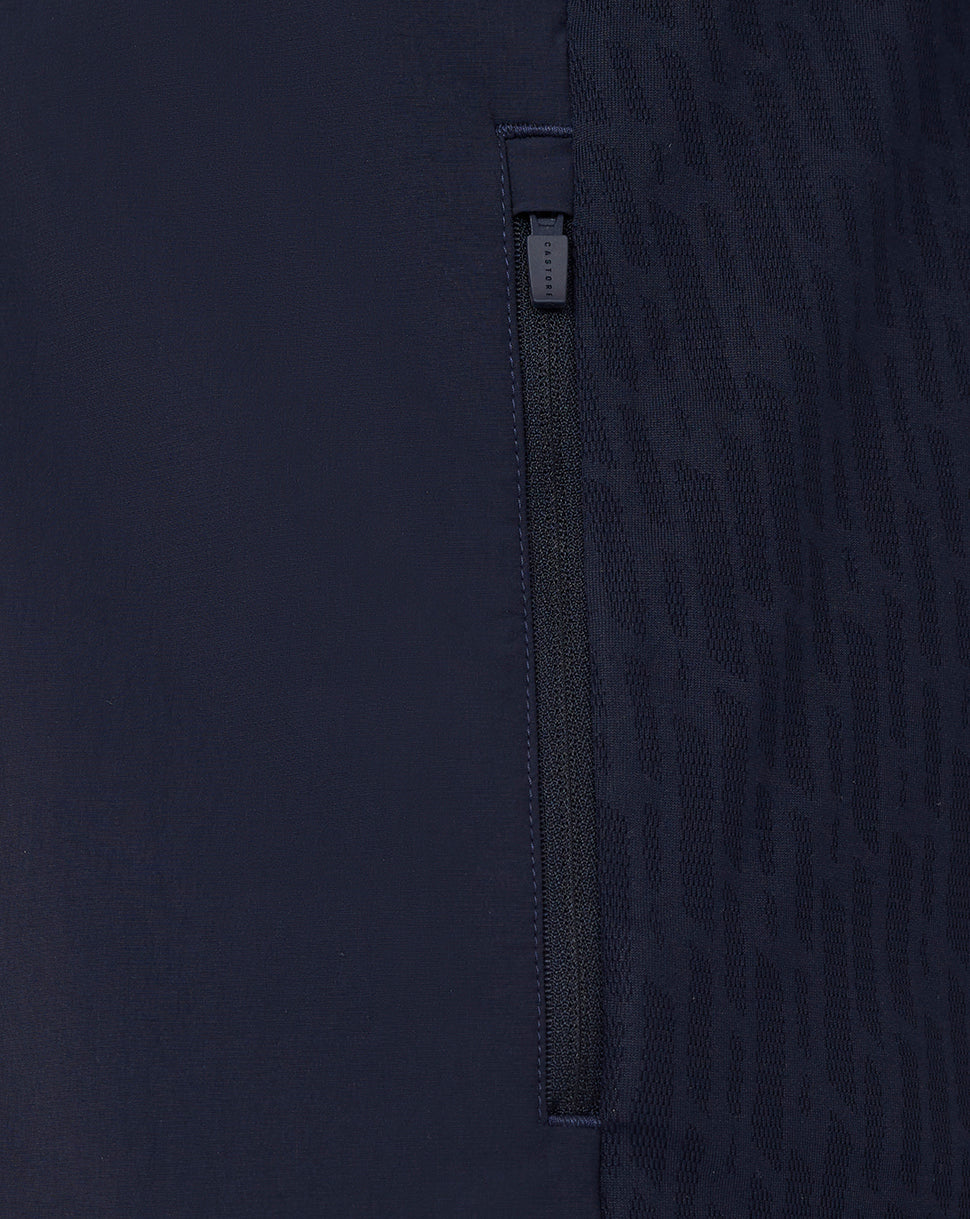 Close-up of a dark blue garment with a zipper detail on a matching background