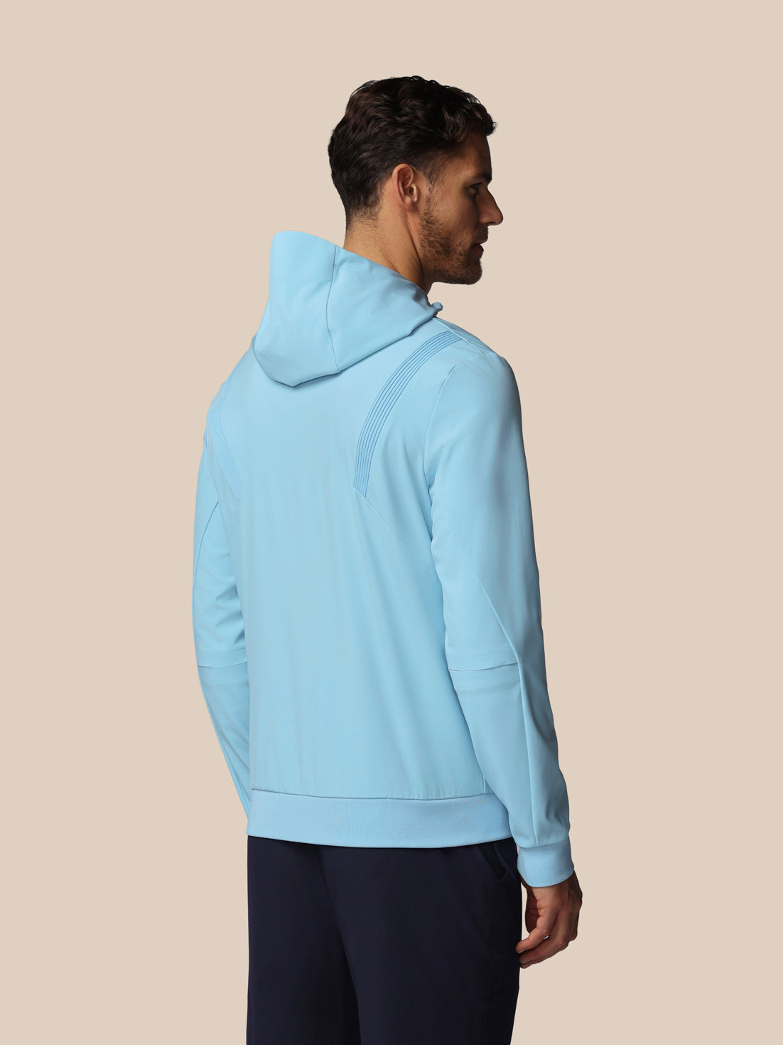 Man wearing a light blue hoodie on a beige background