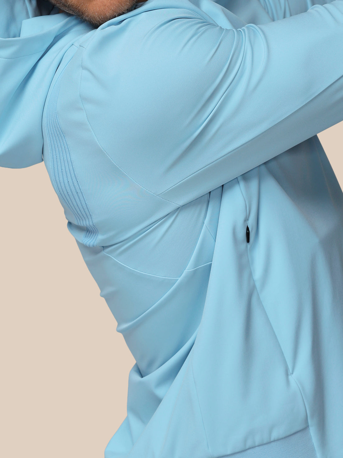Light blue jacket worn by a person on a beige background