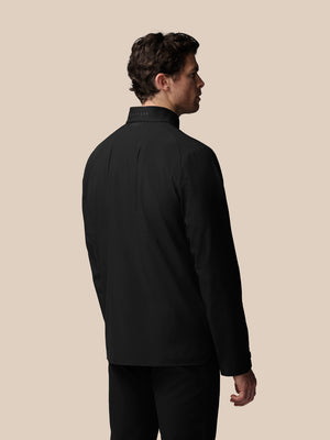 Man wearing a black jacket on a beige background